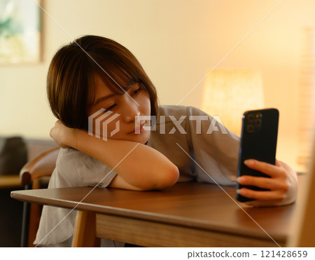 使用智慧型手機的女性的室內肖像 121428659