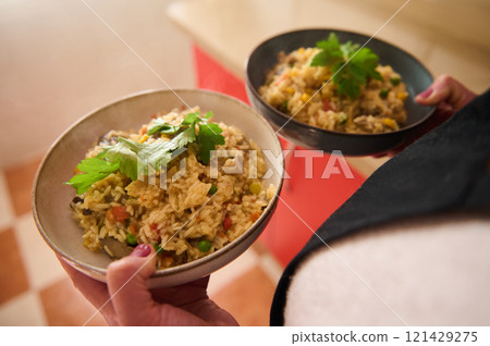 Delicious vegetable paella bowls served and garnished with fresh herbs Delicious vegetable paella bowls served and garnished with fresh herbs 121429275