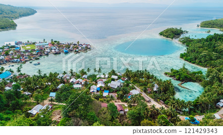 Sea coastline with blue lagoon, tropical landscape and local village in Indonesia. Above drone view 121429343