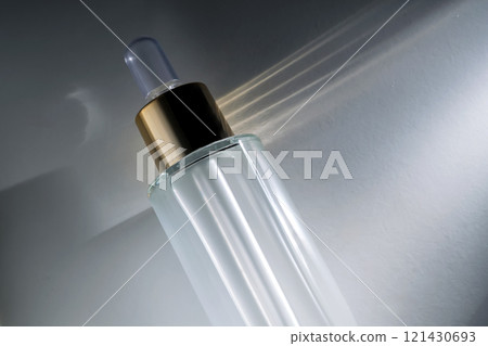 Bottle of face serum with a pipette with a beautiful highlight. 121430693