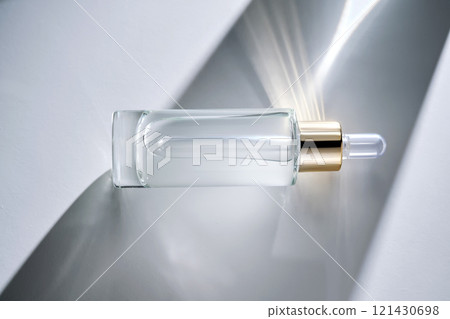 Bottle of face serum with a pipette with a beautiful highlight. Bottle of face serum with a pipette with a beautiful highlight. 121430698