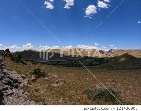 Endless steppe against the backdrop of a blue sky 121430903