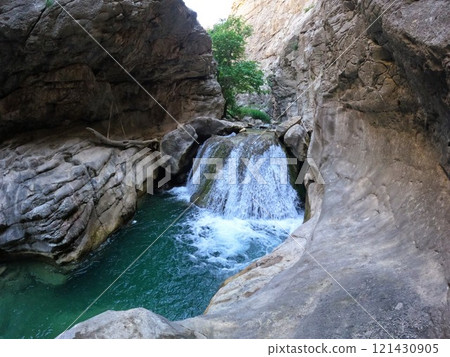 Aksu waterfall with fast flowing and clear water, surrounded by rocks Aksu waterfall with fast flowing and clear water, surrounded by rocks 121430905
