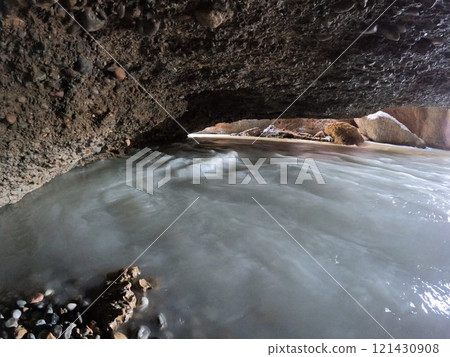 Aksu underground river with white water, stone arches and sun rays in the background Aksu underground river with white water, stone arches and sun rays in the background 121430908