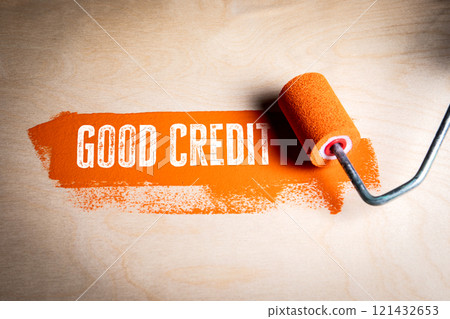 Good Credit. Text and orange paint and paint roller on wooden background Good Credit. Text and orange paint and paint roller on wooden background 121432653