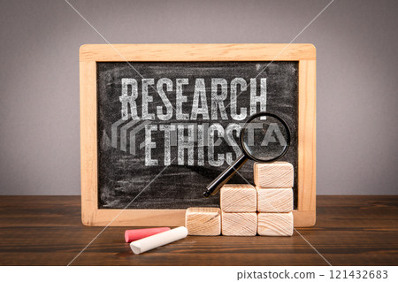 Research ethics. Miniature chalkboard and magnifying glass on a wooden table Research ethics. Miniature chalkboard and magnifying glass on a wooden table 121432683