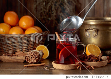 Mulled wine is poured into a glass cup. Mulled wine is poured into a glass cup. 121433393
