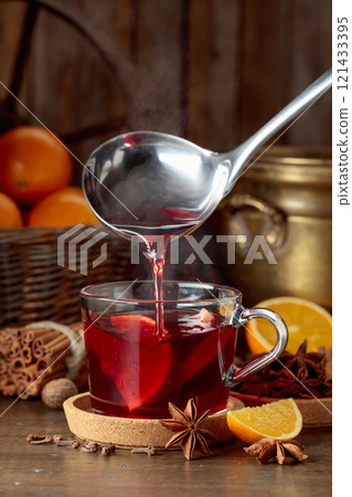 Mulled wine is poured into a glass cup. Mulled wine is poured into a glass cup. 121433395