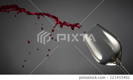 Glass and red wine splash on a dark background. Glass and red wine splash on a dark background. 121433402