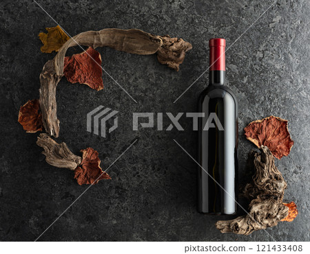 Bottle of red wine on a black stone background. 121433408