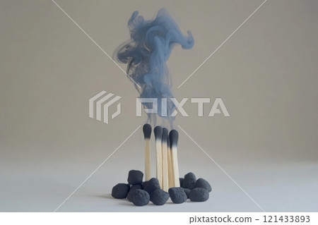 Smoke from burnt matches rising above scattered pebbles in minimalist setting 121433893