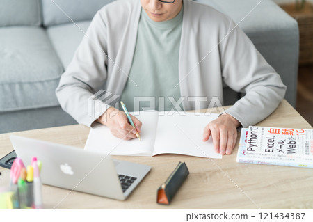 Young man reskilling on a computer, no face 121434387
