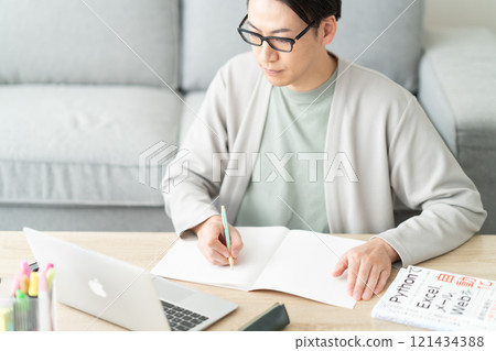 A young man sorting expenses for accounting purposes while looking at receipts 121434388