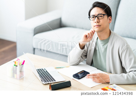 A young man struggling to sort his tax return 121434398