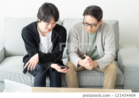 年輕人邊看智慧型手機邊聊天 121434404