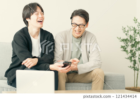 Young men chatting while looking at their smartphones 121434414