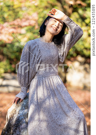 秋天公園裡微笑著獨自站立的女人 121435895
