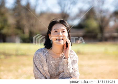 Middle-aged woman relaxing on the grass in the park Middle-aged woman relaxing on the grass in the park 121435984