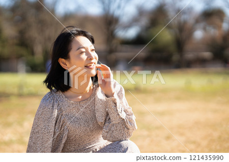 中年婦女在公園的草地上放鬆 121435990