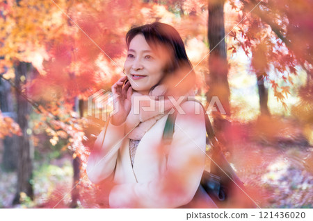 A middle-aged woman viewing autumn leaves A middle-aged woman viewing autumn leaves 121436020
