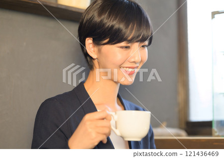 一位女士在咖啡館喝咖啡時看著電腦 一位女士在咖啡館喝咖啡時看著電腦 121436469