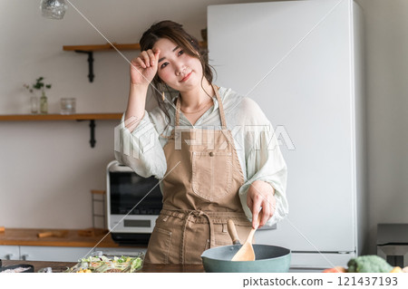 Female using a frying pan in the kitchen (tired) Female using a frying pan in the kitchen (tired) 121437193