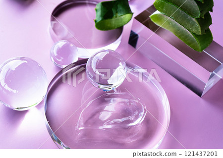 Soft gel drops and aloe leaves on a pastel backdrop, evoking serene spa vibes. High angle view Soft gel drops and aloe leaves on a pastel backdrop, evoking serene spa vibes. High angle view 121437201
