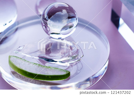 Aloe vera slice and serum droplets rest on a glass dish, emphasizing a clean spa atmosphere. Aloe vera slice and serum droplets rest on a glass dish, emphasizing a clean spa atmosphere. 121437202