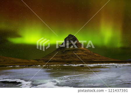 Panoramic night views of northern lights or polar lights appear over Kirkjufell Mountain 121437391