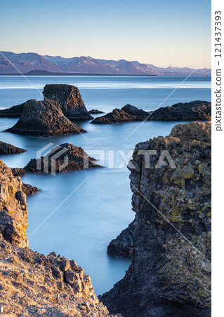 Panoramic view of rock cliffs with sunshine on the coast from Dyrholaey, Iceland Panoramic view of rock cliffs with sunshine on the coast from Dyrholaey, Iceland 121437393