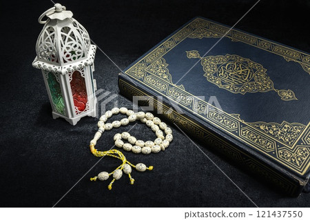 Arabic lantern with prayer beads and the Quran on a black background. Decoration for Muslim holidays celebration 121437550