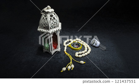 Arabic lantern with prayer beads and a qibla compass on a black background. Decoration for Muslim holidays celebration 121437551