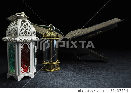 Arabic lanterns and Quran on quran matt with a black background. Decoration for Muslim holidays celebration 121437554
