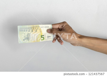 Human hand holding five euro banknote cash on white background Human hand holding five euro banknote cash on white background 121437567