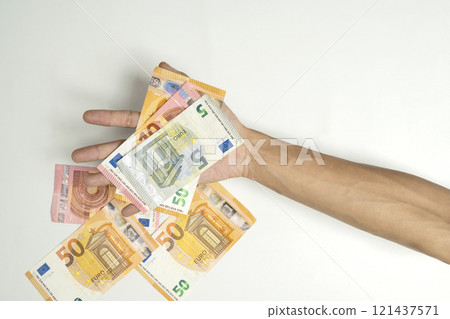 Human hand holding euro banknote cash on white background Human hand holding euro banknote cash on white background 121437571
