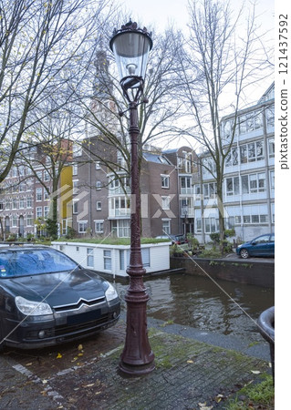 Street lamp on the sidewalk beside the canal Street lamp on the sidewalk beside the canal 121437592