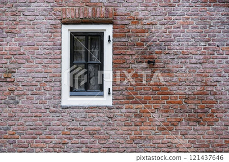 Facade view of window with curtain on brick wall background 121437646