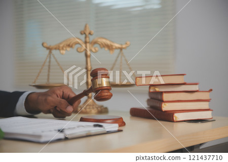 Judge gavel and miniature car symbolize auction or court case against driver who has accident and receiving vehicle insurance payment be on table in front of hands of lawyers. Selective focus Judge gavel and miniature car symbolize auction or court case against driver who has accident and receiving vehicle insurance payment be on table in front of hands of lawyers. Selective focus 121437710