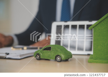 Judge gavel and miniature car symbolize auction or court case against driver who has accident and receiving vehicle insurance payment be on table in front of hands of lawyers. Selective focus Judge gavel and miniature car symbolize auction or court case against driver who has accident and receiving vehicle insurance payment be on table in front of hands of lawyers. Selective focus 121437717