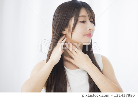 A young woman looks in the mirror and worries about her skin 121437980