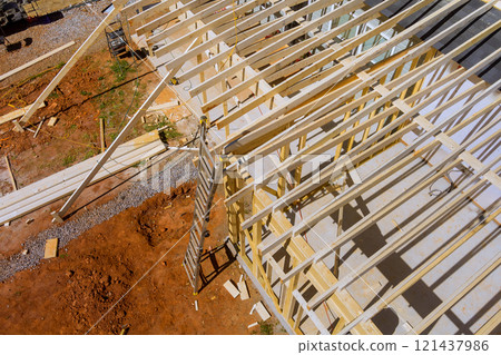 Workers are constructing wooden frame at building site, roofing frame works in construction of new house 121437986