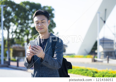 A man holding a smartphone in the city 121438051