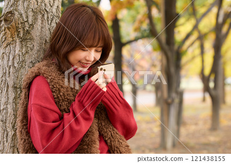 A woman wearing a fur vest taking a walk at an autumn performance 121438155