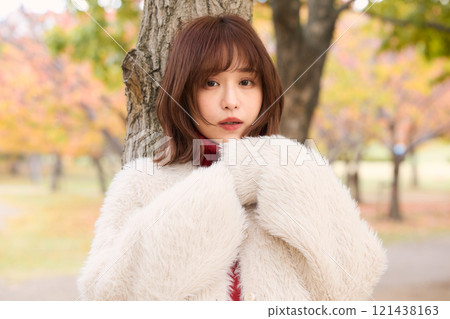 A woman wearing a fur jacket taking a walk during an autumn performance 121438163