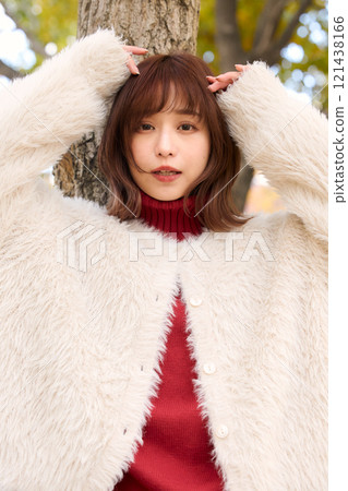 A woman wearing a fur jacket taking a walk during an autumn performance 121438166
