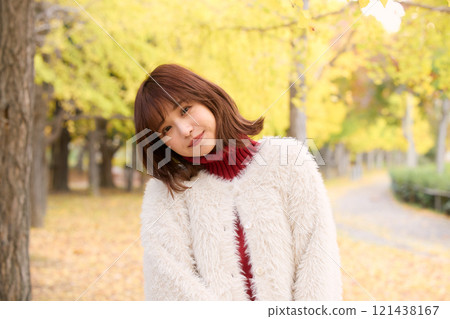 A woman wearing a fur jacket taking a walk during an autumn performance 121438167