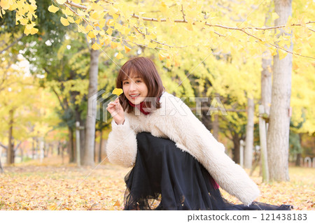 A woman wearing a fur jacket taking a walk during an autumn performance A woman wearing a fur jacket taking a walk during an autumn performance 121438183