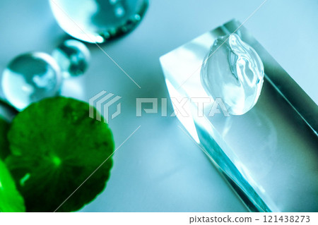 Aloe serum and centella drops rest on a clear surface among calming spa elements. Aloe serum and centella drops rest on a clear surface among calming spa elements. 121438273