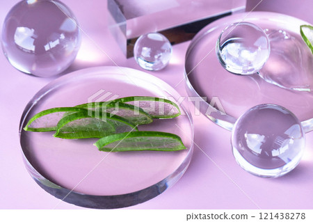 Aloe leaves and centella serum are artistically arranged in a tranquil spa setting. 121438278