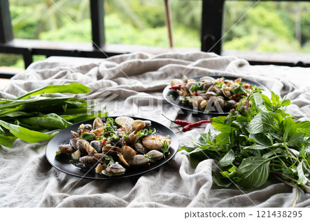 Tables adorned with clams and mussels, garlic, herbs, and lush greenery. Tables adorned with clams and mussels, garlic, herbs, and lush greenery. 121438295